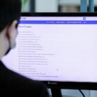 Homem em frente a tela de computador no site da Prefeitura