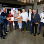 Prefeito, vice-prefeita e outras autoridades seguram ordem de serviço para pavimentar ruas