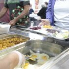 Imagem de uma pessoa se servindo em um buffet de comida
