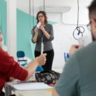 Professore em pé explica técnica para pessoas sentadas