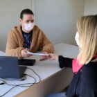 Servidora entrega cartão de vacina para mulher
