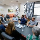 Integrantes do conselho sentados à mesa com o prefeito