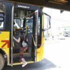 Imagem de uma mulher embarcando em um ônibus coletivo municipal