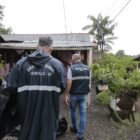 Agentes da Defesa Civil na frente de uma casa