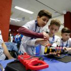 Imagem de alunos e professora estudando um robô