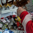 Mãos de uma senhora artesã trabalhando com seus produtos