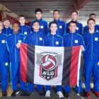 Atletas de Joinville, uniformizados, posam para foto segurando bandeira