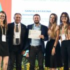 Secretário e servidores da Secretaria da Saúde posam para foto com premiação