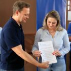 Prefeito entrega ordem de serviço para mulher representante da empreiteira vencedora, observado por autoridades