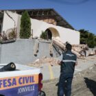 Dois agentes da Defesa Civil avaliam casa afetada por deslizamento
