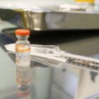 Seringa e frasco com vacina contra Covid em mesa