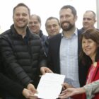 Prefeito, vice, secretário de educação de Joinville seguram lei ao lado de outras autoridades