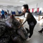 Mulher entrega saco com doações