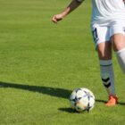 Jogadora prepara-se para chutar bola de futebol