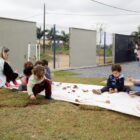 Professoras brincam na grama com as crianças