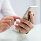 mãos digitam em um celular