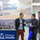 Pessoas passam por estande da Prefeitura
