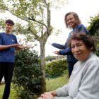 Avó e netos perto de árvores plantadas há dez anos
