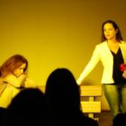 Mulher segura rosa em encenação de teatro