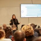 Mulher fala para plateia em auditório