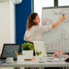 Mulher desenha gráficos em quadro durante apresentação