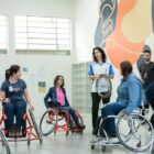 Pessoas em cadeira de rodas participam de atividade para conscientizar sobre inclusão