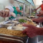 Homem é servido com comida em buffet