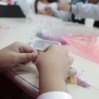 Mãos de criança montando colar