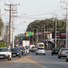 Imagem de uma rua de Joinville com tráfego de veículos