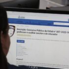 Jovem observa site da prefeitura, na página do concurso