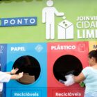 Duas mulheres depositam lixo reciclável no ecoponto