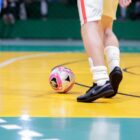 Menino joga bola em quadra