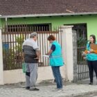 Agentes orientam cidadão em frente de sua casa