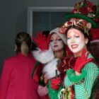 Atores, com figurinos de Natal, acenam para a câmera