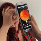 Paciente recebe exame do fundo de olhos com um aparelho portátil