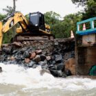 Retroescavadeira trabalha para desobstruir ponte