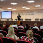 Secretário de educação fala segurando microfone em frente a plateia