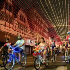 ciclistas circulam em rua com decoração natalina