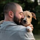 Homem segura cão no colo