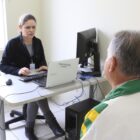 Mulher atende usuário em sala de CRAS