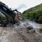 Caminhão descarrega pedras em estrada