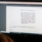 Mulher olha para tela de computador com detalhes da nova lei