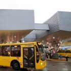 Fotografia de um ônibus passando em frente a um terminal de passageiros