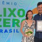 Mulher e homem posam para foto com placa de reconhecimento