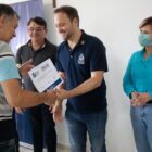 Prefeito Adriano Silva entrega documento para homem, acompanhado por autoridades