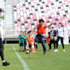 Técnica de futebol treina meninos em gramado