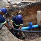 Homens trabalham em obra para instalar tubulação