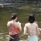 Duas mulheres tomam banho de rio