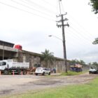 Caminhões e trabalhadores em via que recebe obras de abastecimento