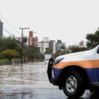 Carro da Defesa Civil estacionado próximo a área com alagamento